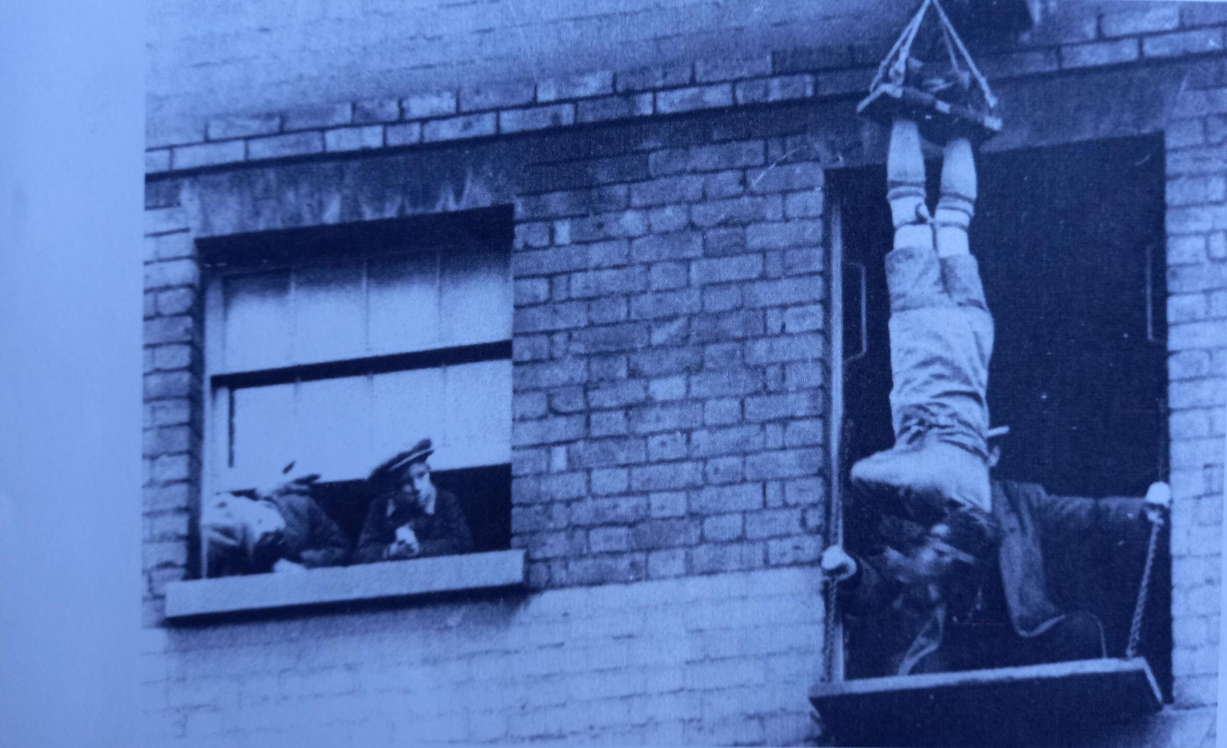 No doubt to promote his show, an escapologist tries his luck from an upper window of the Theatre Royal